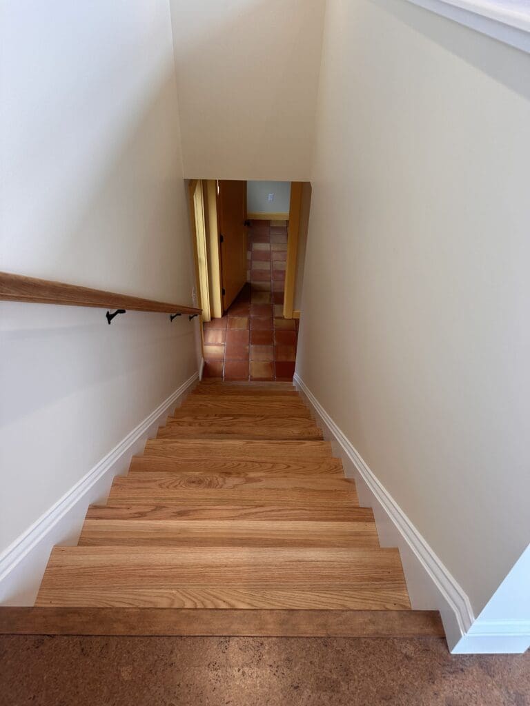 Maine custom flooring installation with wooden steps and red tile at the bottom